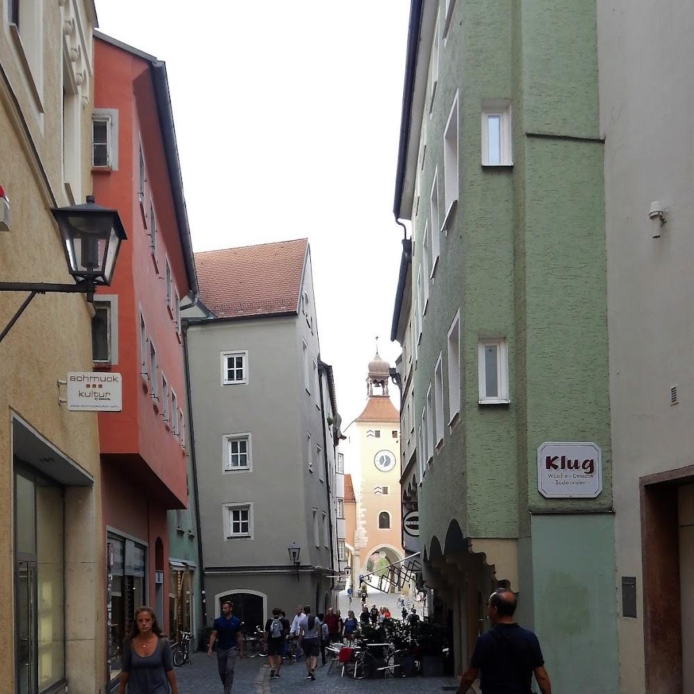 A narrow street with old buildings and a clock tower.